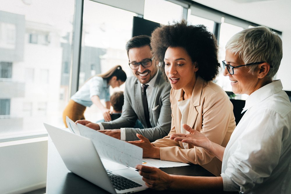 Coworkers sitting at desk while reviewing investment information about their client.