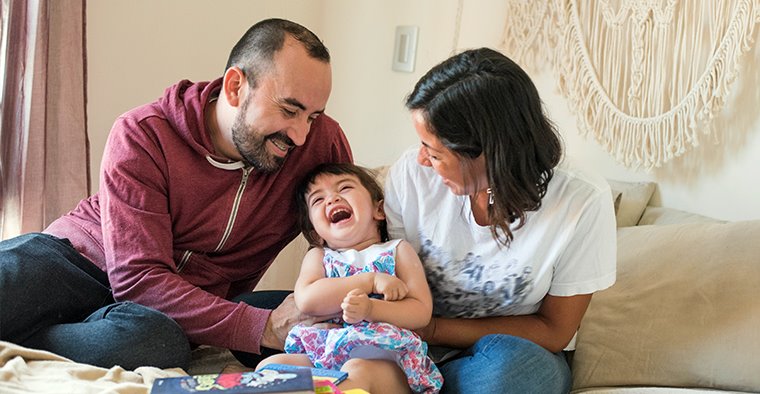 Mother and father playing with small child.