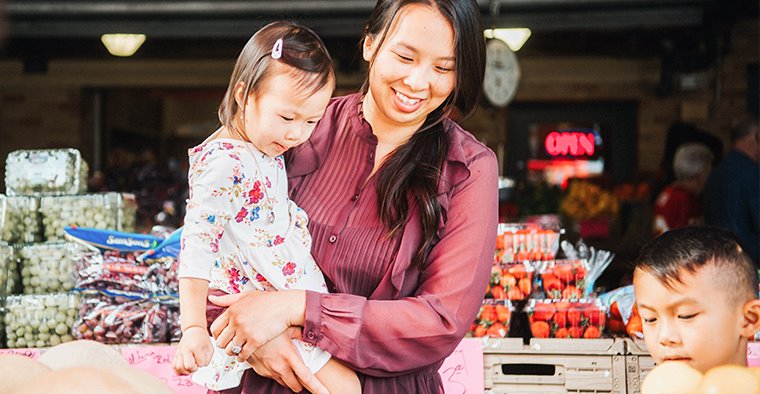 Mother shopping with two children in grocery store.