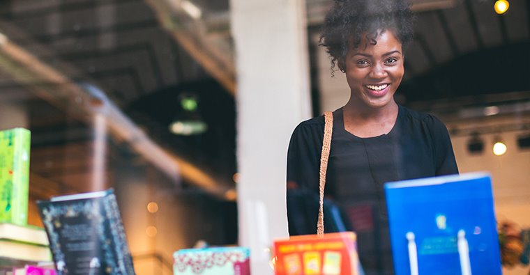 Woman smiling while shopping at a book store.
