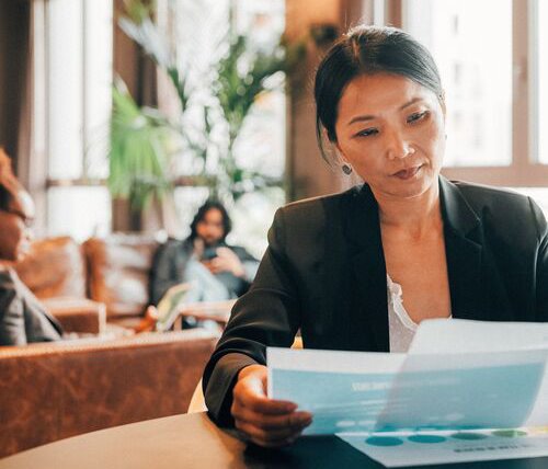 Young woman holding a piece of paper while reviewing her retirement plans